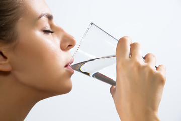 Young woman drinking water from glass - obrazy, fototapety, plakaty