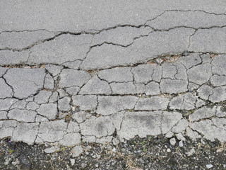 Obraz premium Old worn and cracked asphalt with cracks