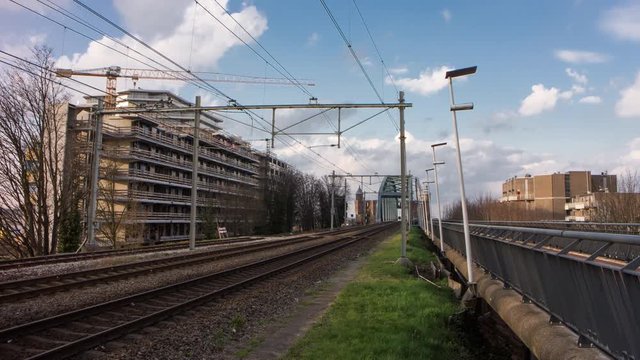 Railroad traffic with distant views of railway bridge, 4K time lapse