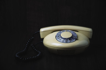 front of old-fashioned phone on a dark wooden background. horizo