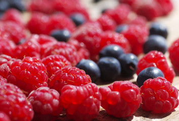 Juicy mature berries of  raspberry and bilberry  close up. Berry background