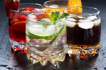assortment of fresh iced fruit drinks on a dark background