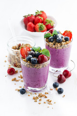 Blueberry dessert with granola in glass on a white background
