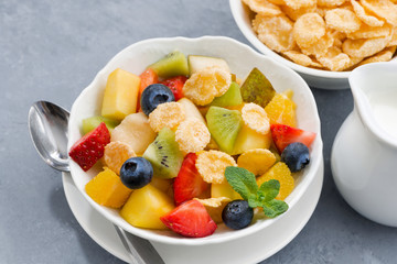 bowl of fresh fruit salad with corn flakes, closeup top view