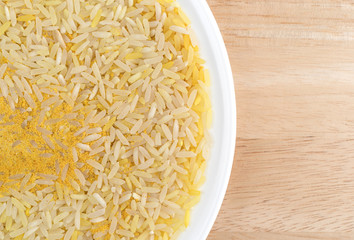 Saffron yellow rice on a white plate and table top.