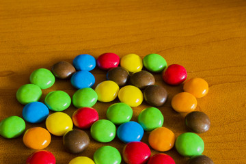 Mixed colorful sweet candies on wooden background