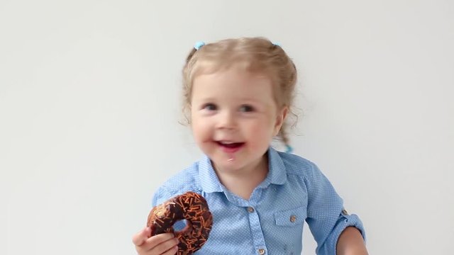 Little girl biting a chocolate donut