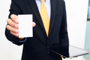 Businessman holding and showing blank business card.