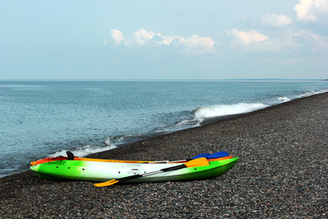 Colorful kayaks and canoes on stony beach