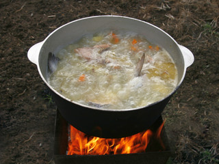 Delicious fish soup in the cauldron on the nature.