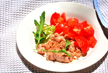Tuna dish with tomatoes and arugula for a delicious meal.