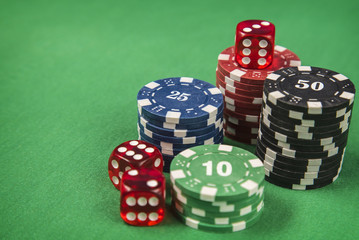 Gambling chips and poker card on green felt background