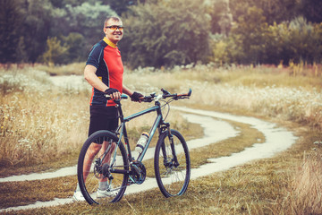 Obraz premium man cyclist rides in the forest on a mountain bike.