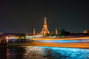 Naklejka premium Temple of dawn or Wat Arun with speed of boat