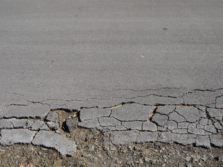 Old worn and cracked asphalt with cracks