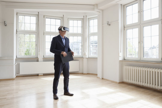 Real Estate Agent Wearing Virtual Reality Glasses In Empty Apartment