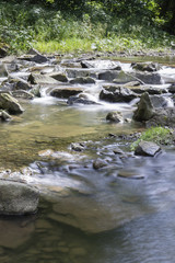 Naklejka na ściany i meble The river - flowing water between the rocks.