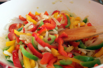 Mixed vegetables in a pan, red, yellow and green peppers, onions