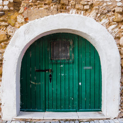 Ancient wooden door in old stone  wall.  Wooden Door in Old City