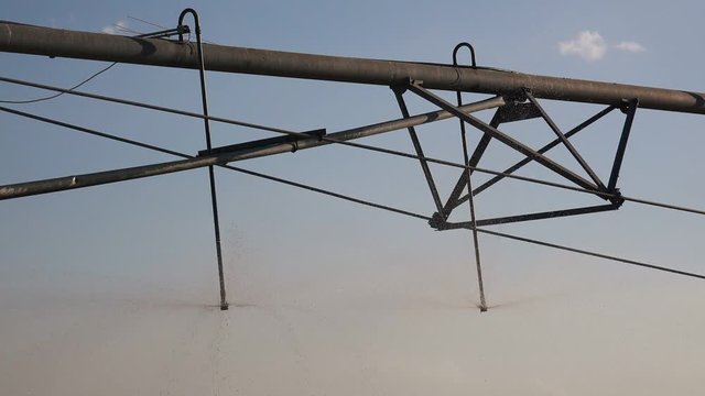 Irrigation sprinklers on agricultural field, detail of industrial machinery used for watering crops on cultivated landscape