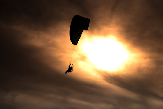 Paraglider flies on background of sunset sky