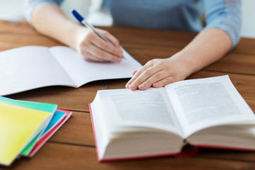 close up of student with book and notebook at home