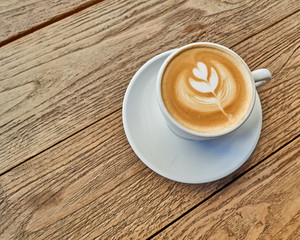 cappuccino cup perspective on grunge wooden table