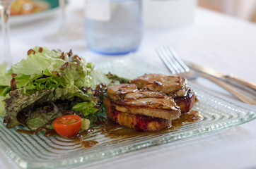 Foie gras, goose duck liver with green salad on plate in the res