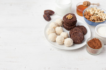Raw vegan paleo style cookies selection, made with nuts, coconut oil, honey and dates, selective focus on closest macaroon