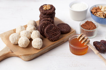 Raw vegan paleo style cookies selection, made with nuts, coconut oil, honey and dates, selective focus on closest macaroon