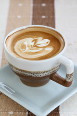 A cup of hot cappuccino on table.