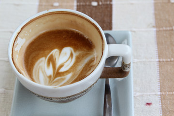 Empty cup of hot cappuccino on table.
