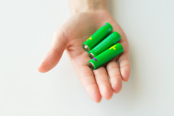 close up of hand holding green alkaline batteries