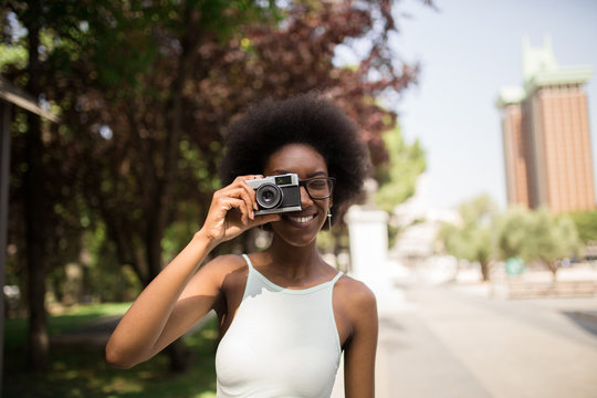 Afro Woman Taking Pictures in the Street