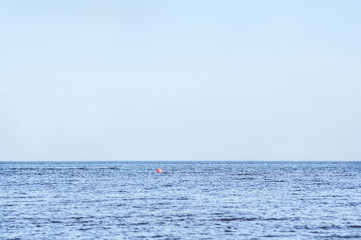 calm sea landscape with a lone red buoy in the distance and the fishermen on the boat