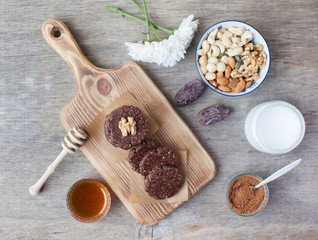 Raw vegan paleo style cookies, made with nuts, coconut oil, honey and dates, selective focus on the walnut on the cookie, top view