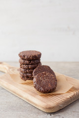 Raw vegan paleo style cookies, made with nuts, coconut oil, honey and dates, selective focus on the nearest cookie