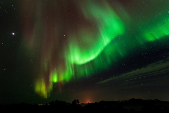 paesaggio notturno con stelle e aurora boreale verde