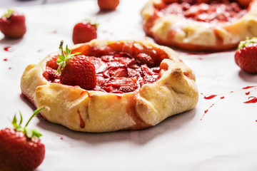 Rustic Tarts with strawberries on a white paper for baking 