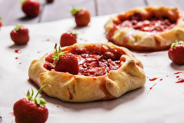 Rustic Tarts with strawberries on a white paper for baking 