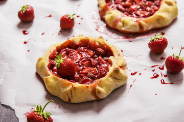 Rustic Tarts with strawberries on a white paper for baking 
