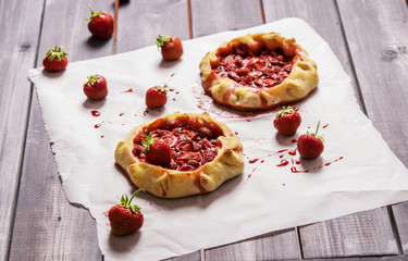 Rustic Tarts with strawberries on a white paper for baking 