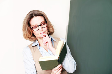 Lehrerin an der Tafel mit Buch