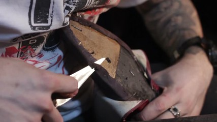 Cobbler sews shoes. Shoemaker cutting leather