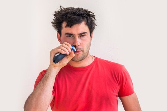 Young Happy Man Shaving With Electric Razor