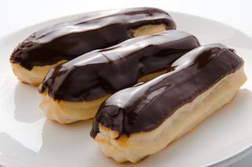 Three eclair on a white plate