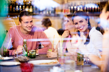 Young beautiful people with cocktails in bar or club