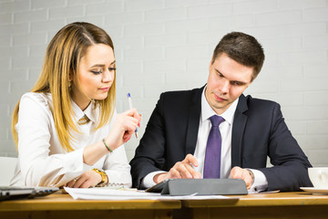 Two business people using tablet computer in office