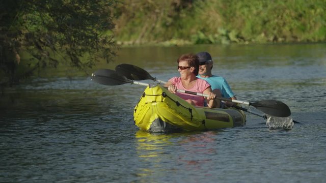 SLOW MOTION: Happy smiling couple in boat oaring on river