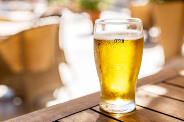 Glass of light beer on the wooden table.